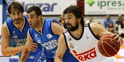 El base del Real Madrid Sergio Llull avanza con el balón ante los jugadores del Gipuzkoa Basket Jared Jordán, en el centro, y David Doblas.