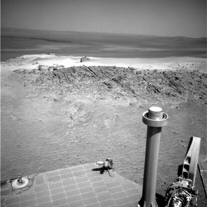 Panorama de Marte con parte de un panel solar del 'Opportunity' y un mástil, acercándose al cráter Endeavour.
