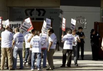 Un grupo de personas protesta con pancartas a la entrada de la Audiencia Nacional en San Fernando de Henares, al inicio del juicio oral contra los ocho acusados de la quiebra de Sintel -antigua filial de Telefónica-, el pasado mes de junio.
