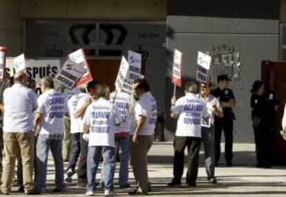 Un grupo de personas protesta con pancartas a la entrada de la Audiencia Nacional en San Fernando de Henares, al inicio del juicio oral contra los ocho acusados de la quiebra de Sintel -antigua filial de Telefnica-, el pasado mes de junio.