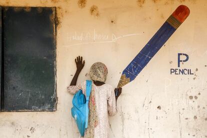 Aisha, de 13 años, usa un lápiz mientras finge dibujar en un mural del campo de Yola para desplazados internos. Cuando los miembros de Boko Haram atacaron su ciudad, Gwozo, mataron a su padre y secuestraron a su madre. Ella logró escapar y llegar al campo con su hermana mayor. Ahora cuidan la una de la otra. “Me gusta ir al cole aquí, pero quiero volver a mi pueblo”.