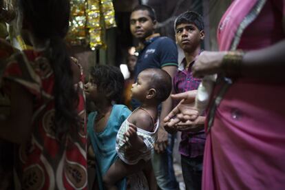 Residentes de Dharavi haciendo cola ante un quiosco situado en una de las estrechas callejuelas de la ciudad que convierten muchas partes de la zona en un verdadero laberinto en el que los visitantes se pierden con facilidad.