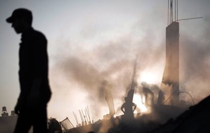 Palestinos buscan entre los escombros de un edificio destruido, tras un ataque israelí, durante la noche en la ciudad de Gaza, el 8 de julio de 2014.