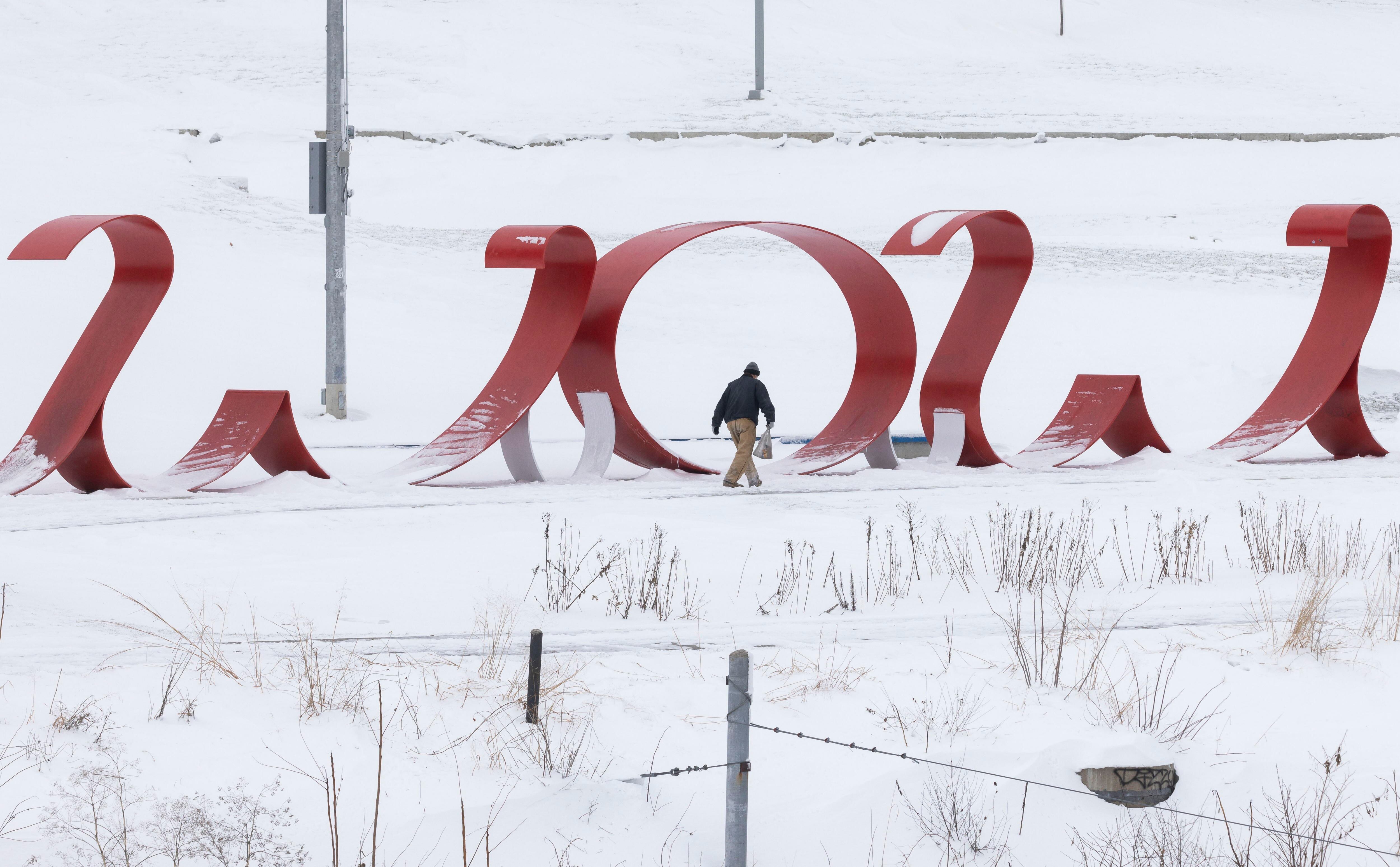 Un hombre camina junto al río y una escultura en Des Moines, el 15 de enero.