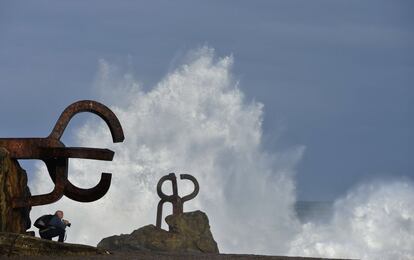 Un fotógrafo espera a la llegada de una ola en 'El Peine de los Vientos' de San Sebastián.