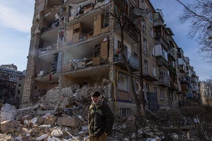 Un hombre camina por delante de un edificio residencial dañado por un bombardeo en el distrito de Podilskyi en Kiev.