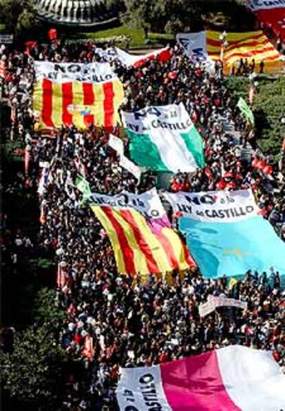 Miles de personas portando gigantes pancartas de protesta en la madrileña Plaza de España.