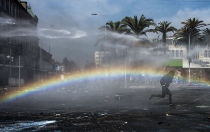 Un manifestante chileno se enfrenta con la policía antidisturbios durante el mítin del Primero de Mayo en Santiago de Chile (Chile).