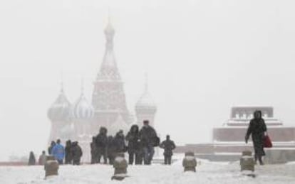 Varias personas caminan por la plaza Roja de Moscú (Rusia) durante la gran nevada de ayer, jueves 29 de noviembre de 2012.