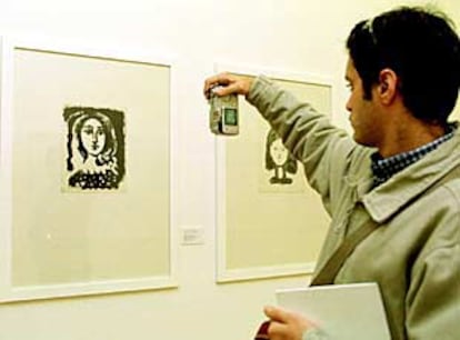 Un visitante de <i>Picasso from Málaga</i> fotografía una obra expuesta con una cámara digital.