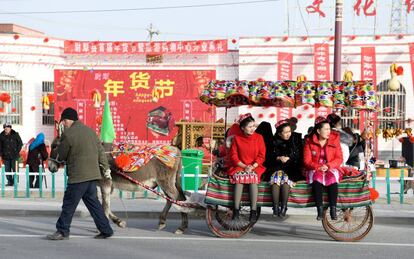 Unas ciudadanas chinas son transportadas en un carro tirado por un burro, a finales del pasado enero en Lopnur (Xinjiang).