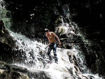Un muchacho juega en una cascada de un nacimiento de agua en la Huasteca Potosina.