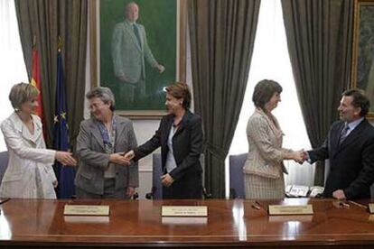 Los representantes de los dos Gobiernos se saludan durante el acto de firma del convenio en Madrid.
