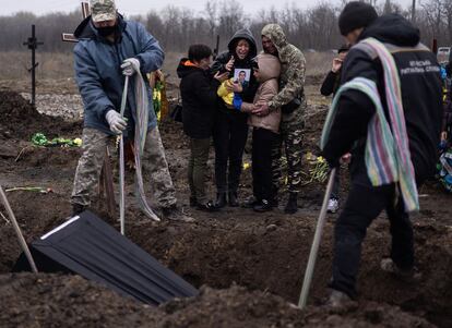 Familiares de un soldado difunto durante el entierro multitudinario de 19 soldados, en el cementerio militar de Dnipro el 20 de abril de 2022.