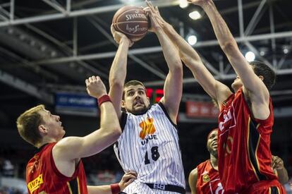 El alero del Uxue Bilbao Basket Adrien Moerman (centro) entra a canasta entre dos jugadores del CAI Zaragoza.