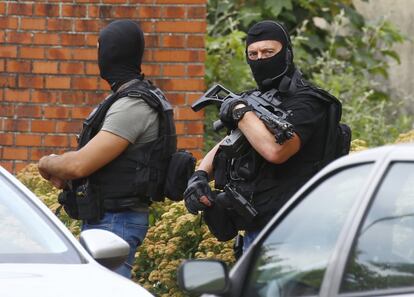 Policía al lado de un edificio en una operación de búsqueda posterior al ataque de una iglesia en Saint-Etienne-du-Rouvray, Francia. 