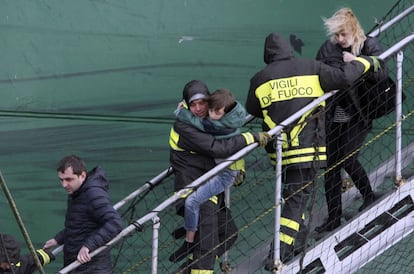 Los bomberos italianos desembarcan en el puerto italiano de Bari a un niño superviviente del incendio desde uno de los cargueros a los que fueron transportados los pasajeros del ferri incendiado por los helicópteros de la marina italiana.