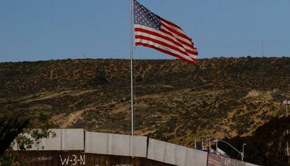Una bandera de EE UU preside un tramo del muro ya construido.