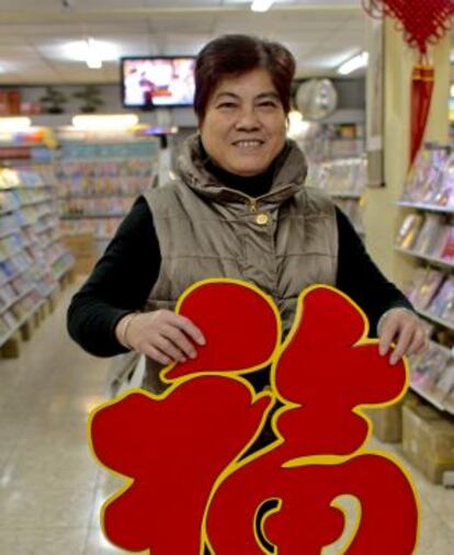 La dependienta de la librería Zhong Hua muestra la palabra "suerte".