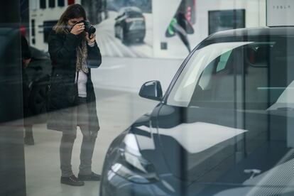 Un cliente toma fotografías de un coche de Tesla en un concesionario