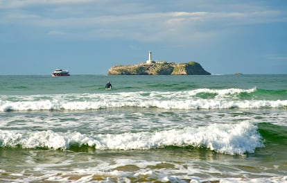 Uno de los ferris junto a la isla de Mouro visto desde la playa de Somo, conocida por sus olas para los amantes del surf.