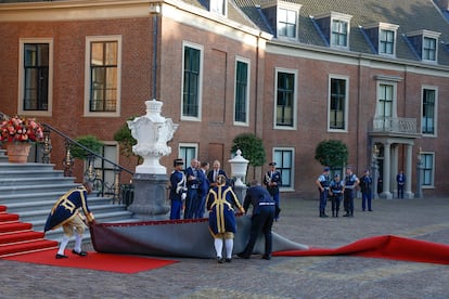 Several workers try to place the red carpet of the guests at the work dinner offered by the Dutch monarchs in the framework of the NATO Summit, this Tuesday at the Huis Ten Bosch Palace in The Hague.