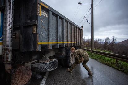 Un soldado letón, miembro de las fuerzas de la OTAN desplegadas en Kosovo, inspecciona este domingo un camión que bloquea una de las principales carreteras que conducen a la frontera con Serbia.