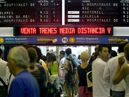 Usuarios del tren, ayer, en la estación de Sants, bajo los paneles informativos.