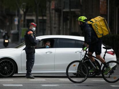 Un rider de Glovo pasa frente a un control policial en Barcelona.