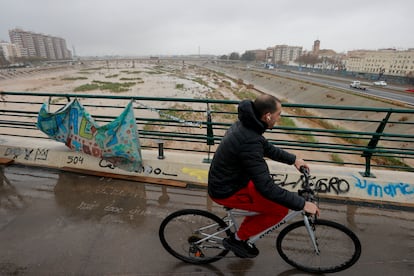 Una persona cruza un puente sobre el nuevo cauce del Turia en Valencia, este mircoles.