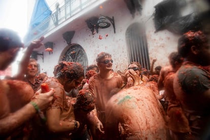 Revellers covered in tomato pulp take part in the "Tomatina" annual food-battle in the Spanish eastern town of Bunol, on August 30, 2023. Around 15,000 people, gathered today in Spain's annual �Tomatina� street battle to hurl each other 120 tons of tomatoes. (Photo by Jose Miguel FERNANDEZ / AFP)