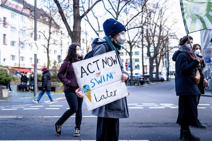 Un manifestante participa en una concentración por el clima, con una pancarta que dice "Actúa ahora o nada después".