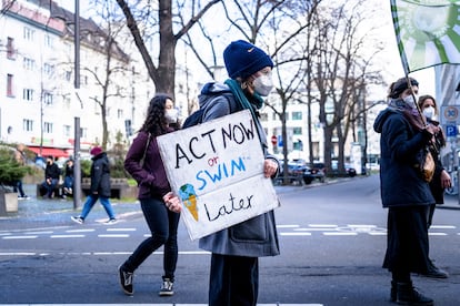 Un manifestante participa en una concentración por el clima, con una pancarta que dice "Actúa ahora o nada después".