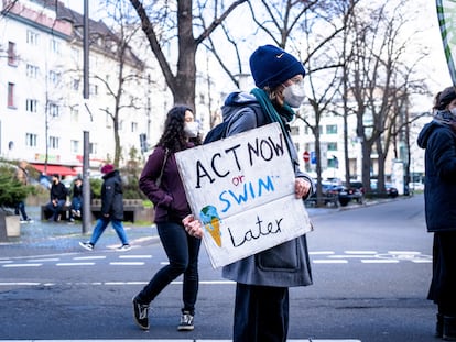 Un manifestante participa en una concentración por el clima en Bonn (Alemania) en 2021, con una pancarta que dice "Actúa ahora o nada después".