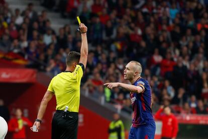 Michael Laudruo le enseñó la 'croqueta, esa jugada de uno contra uno, que te enseña la pelota y te la esconde al mismo tiempo. Iniesta dribla y se va. Eso es lo más caro en el fútbol de hoy en día. En la imagen, el arbitro saca tarjeta amarilla a Iniesta.