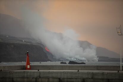 El Cabildo de La Palma ha pedido este miércoles a los habitantes de Tazacorte, un municipio de 4.601 habitantes —según datos del Instituto Nacional de Estadística—, que no salgan de casa después de que la lava del volcán de Cumbre Vieja llegara anoche al mar. En la imagen, columna de humo y lava del volcán de Cumbre Vieja a su llegada al océano Atlántico vista desde el muelle de Tazacorte.