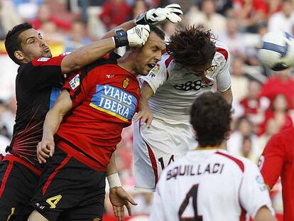 El sevillista Escudé, a la derecha, pelea el balón de cabeza con Ramis y Moyà.