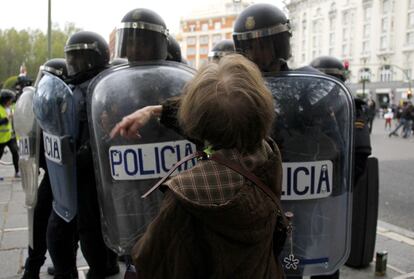Una mujer se enfrenta a la policía antidisturbios durante las cargas policiales en la plaza de Neptuno.