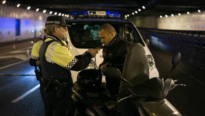 Un agente de la Guardia Urbana de Barcelona hace la prueba de alcoholemia a un motorista. ALBERT GARCIA