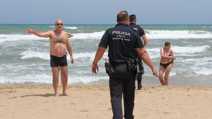 La policía local alerta los bañistas del estado del mar en Guardamar (Alicante).