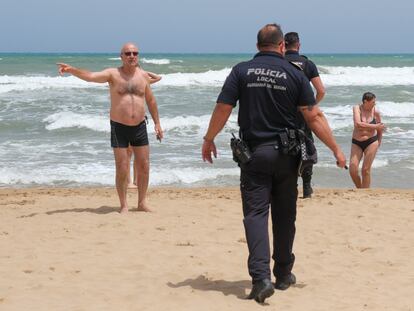 La policía local alerta los bañistas del estado del mar en Guardamar (Alicante).