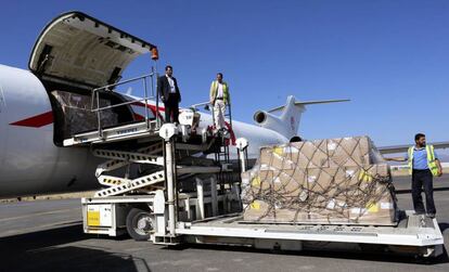 Trabajadores del aeropuerto descargan ayer el env&iacute;o de ayuda humanitaria en San&aacute;.