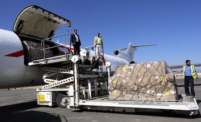 Trabajadores del aeropuerto descargan ayer el envío de ayuda humanitaria en Saná.