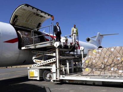 Trabajadores del aeropuerto descargan ayer el env&iacute;o de ayuda humanitaria en San&aacute;.