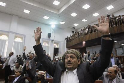 Miembros del parlamento yemení alzan sus manos para votar a favor de la ley que da inmunidad al presidente Saleh.