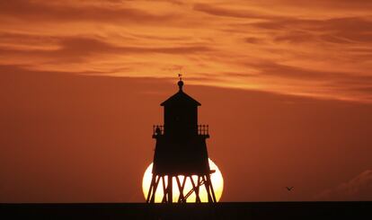 El sol se eleva en el faro de Herd Groyne en South Shields (Inglaterra), el 22 de septiembre de 2018.