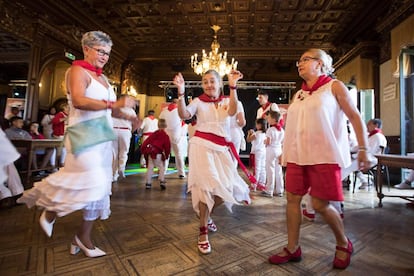 Tres mujeres se mueven al ritmo de la música durante el Baile de la Alpargata, en el festival de San Fermín.