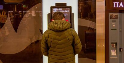 Un hombre retira dinero de un cajero en Moscú.
