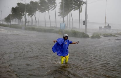 Un agente de tráfico impide el paso a vehículos por una calle inundada en Filipinas, el 15 de septiembre.