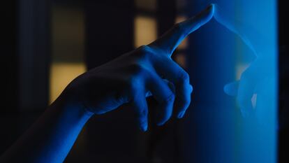 Vista de cerca de la mano de la mujer usando la pantalla táctil interactiva del quiosco electrónico.
